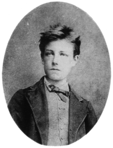 The photographic portrait of Arthur Rimbaud was taken when he was sixteen. The portrait shows the head and torso of a young man with tousled hair, wearing a tie, vest, and jacket. His face is slightly angled and he is looking to the left; his face is serious and his lips are closed.