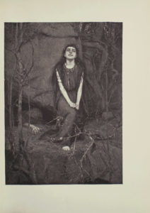 Image is of a woman in a forest She is sitting in the centre of the image her face looking forward Her hands are curled up and resting on her right knee which extends away from her body A crown of leaves is sitting atop the womans long dark hair She is wearing a long sleeveless dark coloured dress with a decorated neckline The top of her right foot is poking out from beneath the dress slightly more than the toes are all that is visible A wraparound golden armlet is around her right upper arm She is shown in full face tilted slightly upward with wide almost demented eyes and a mysterious smile She is sitting in front of a large rock A persons arm is emerging from under the rock their fingers grasping at the ground The figures body is faint seen in the darkness of a large crevice Large roots and small trees branches surround the image The image is vertically displayed